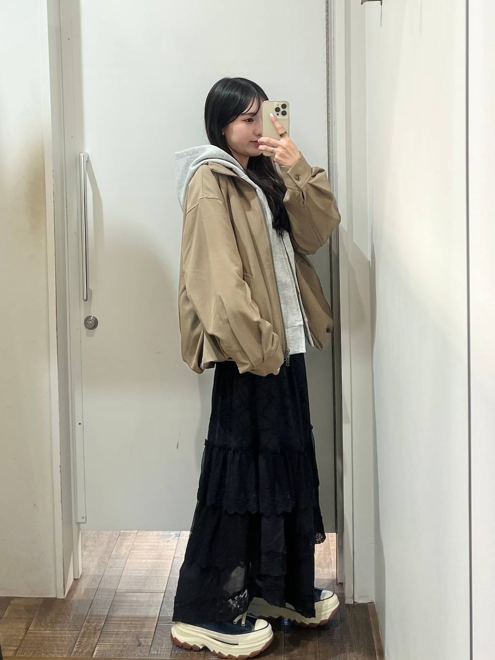 ブルー系のスニーカー、グレー系のパーカー、ブラック系のスカートを着用したレディースの春コーディネートの6枚目の写真