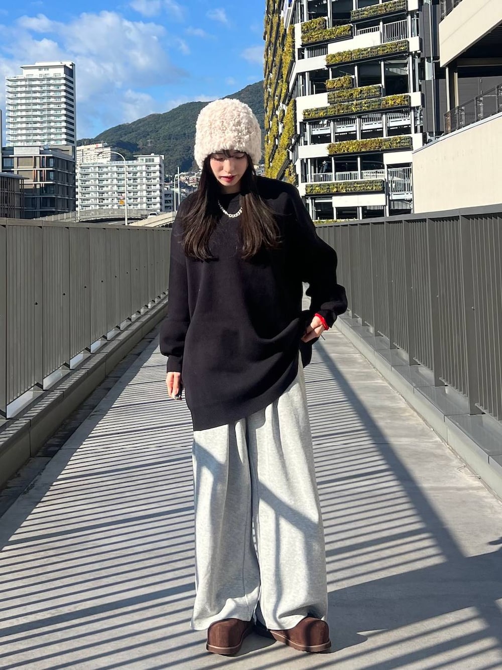 ブラック系のニット/セーター、ブラウン系のその他シューズ、グレー系のスウェットパンツを着用したレディースの冬コーディネートの5枚目の写真