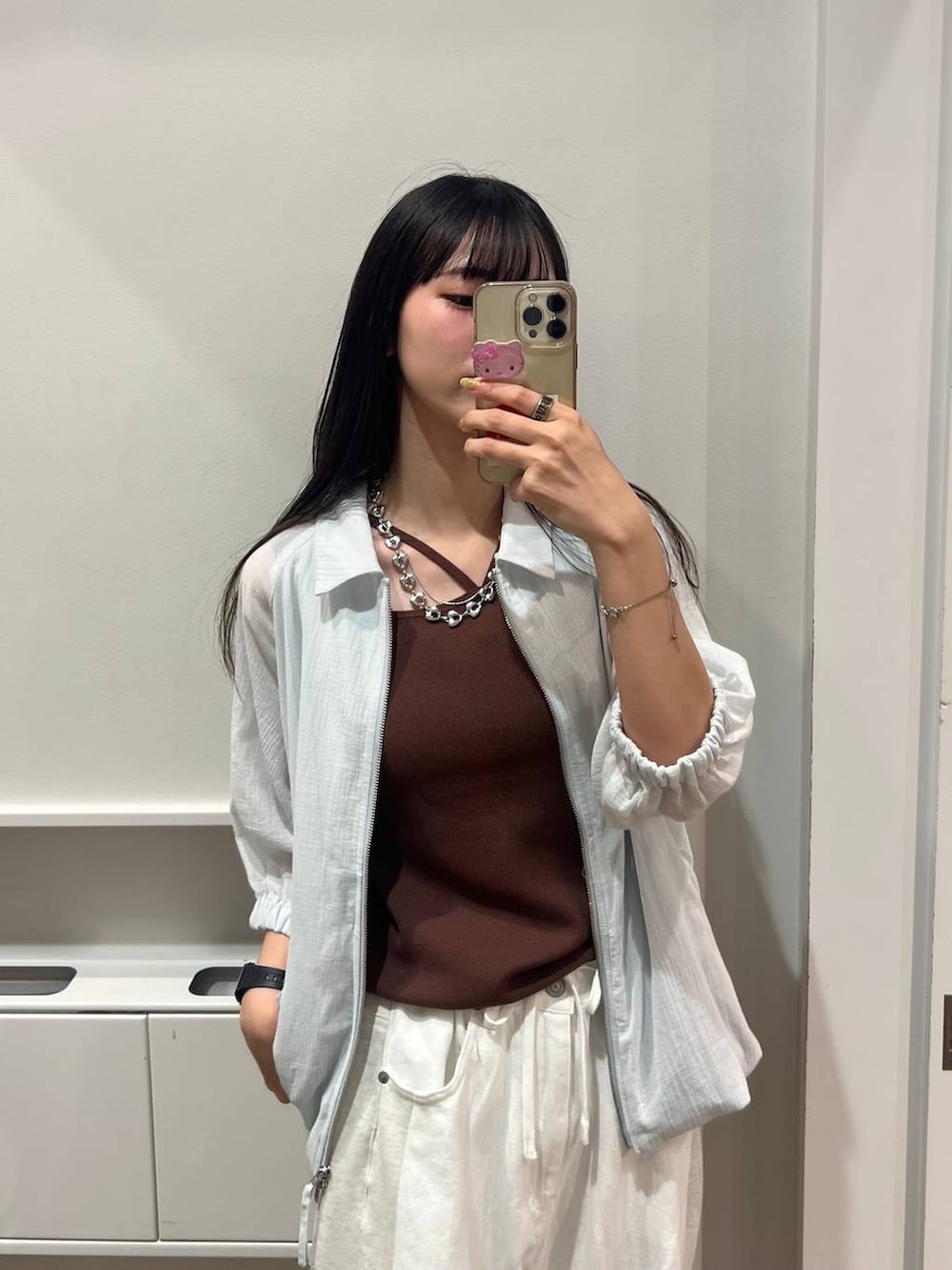 ホワイト系のデニムパンツ、ブラウン系のタンクトップ、ブラック系のパンプスを着用したレディースの夏コーディネートの4枚目の写真