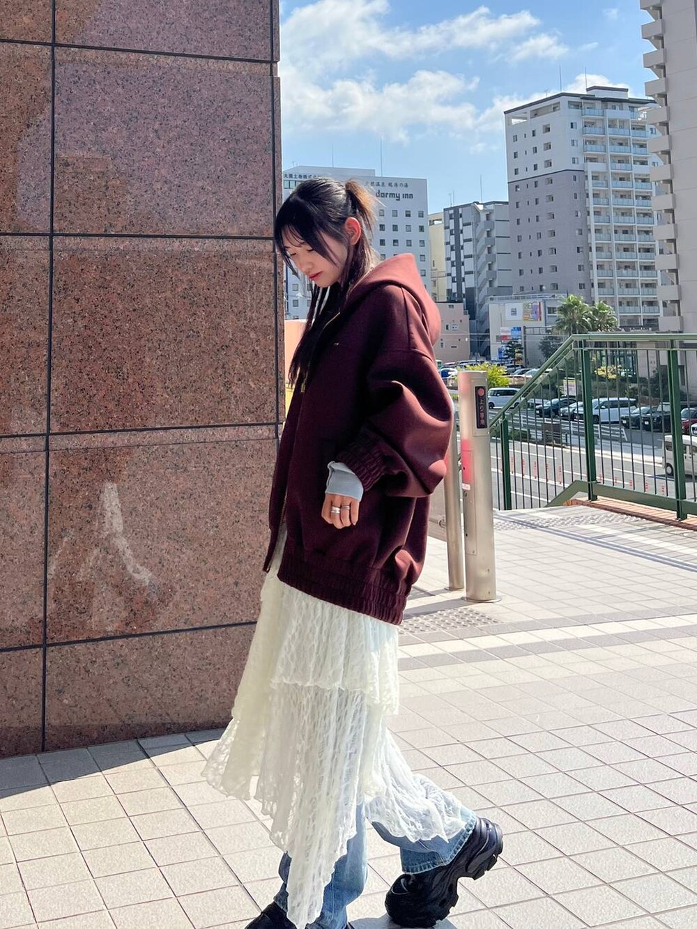 ブラウン系のパーカー、ブラウン系のローファー、ブルー系のデニムパンツを着用したレディースの秋コーディネートの5枚目の写真