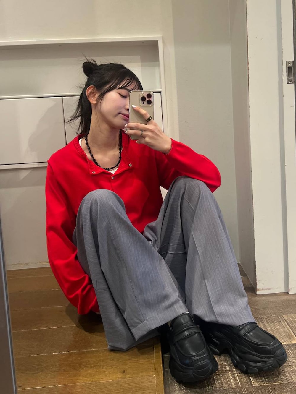 ブラック系のローファー、グレー系のスラックス、レッド系のカーディガン/ボレロを着用したレディースの春コーディネートの2枚目の写真