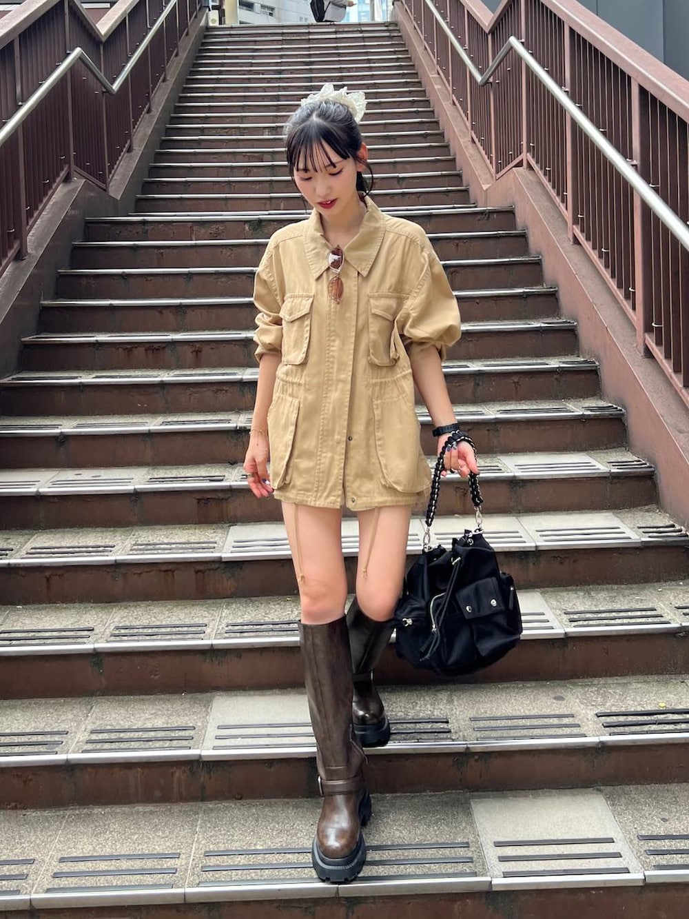 ブラック系のショルダーバッグ、ホワイト系のその他パンツ、ブラウン系のブーツを着用したレディースの夏コーディネートの3枚目の写真