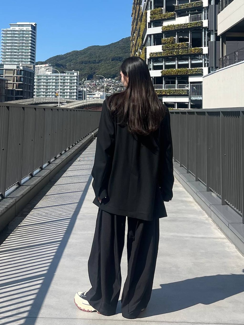 ホワイト系のTシャツ/カットソー、ブラック系のスニーカー、ブラック系のテーラードジャケットを着用したレディースの春コーディネートの5枚目の写真