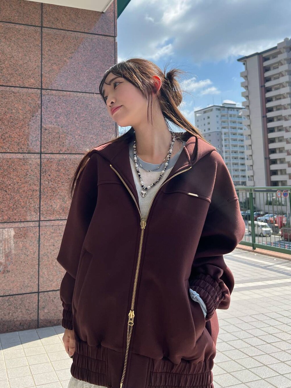 ブラウン系のパーカー、ブラウン系のローファー、ブルー系のデニムパンツを着用したレディースの秋コーディネートの3枚目の写真