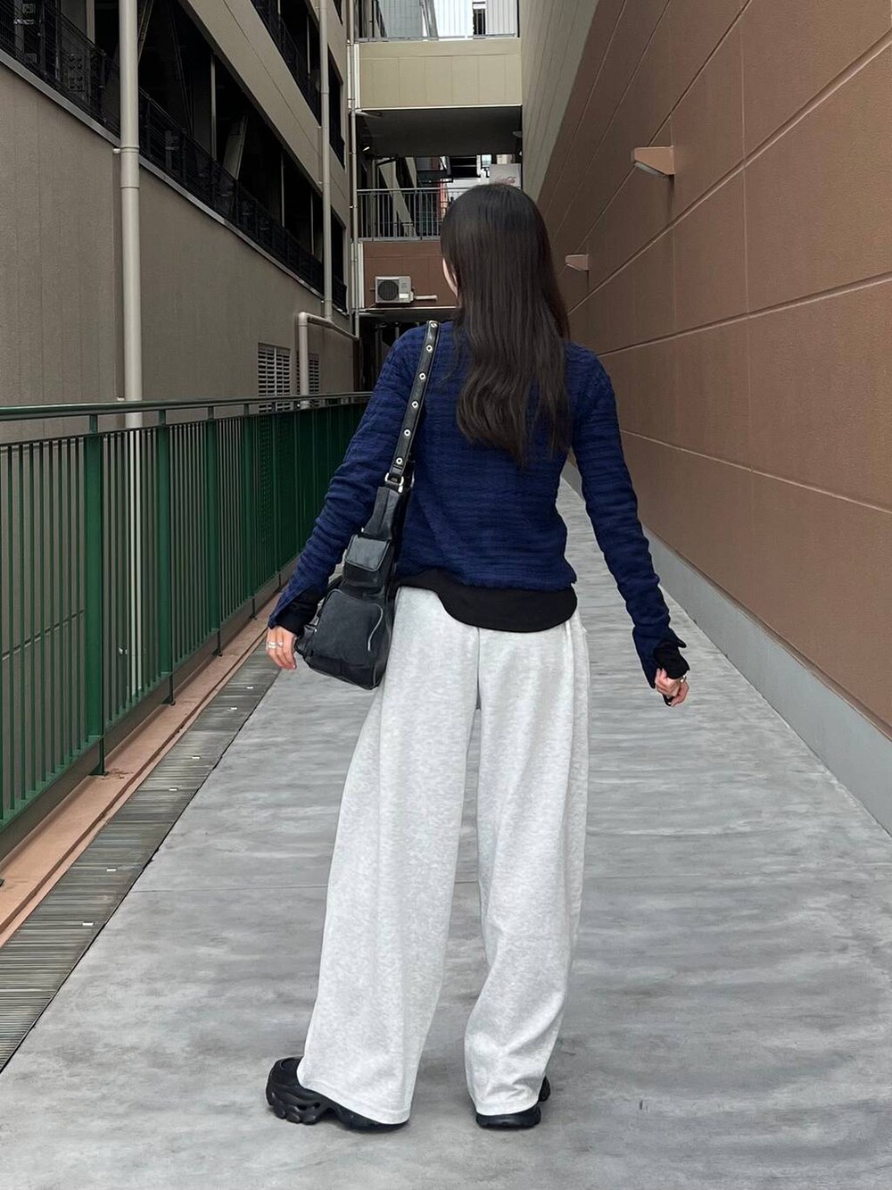 ブラック系のTシャツ/カットソー、ブラック系のショルダーバッグ、ブラック系のローファーを着用したレディースの秋コーディネートの6枚目の写真