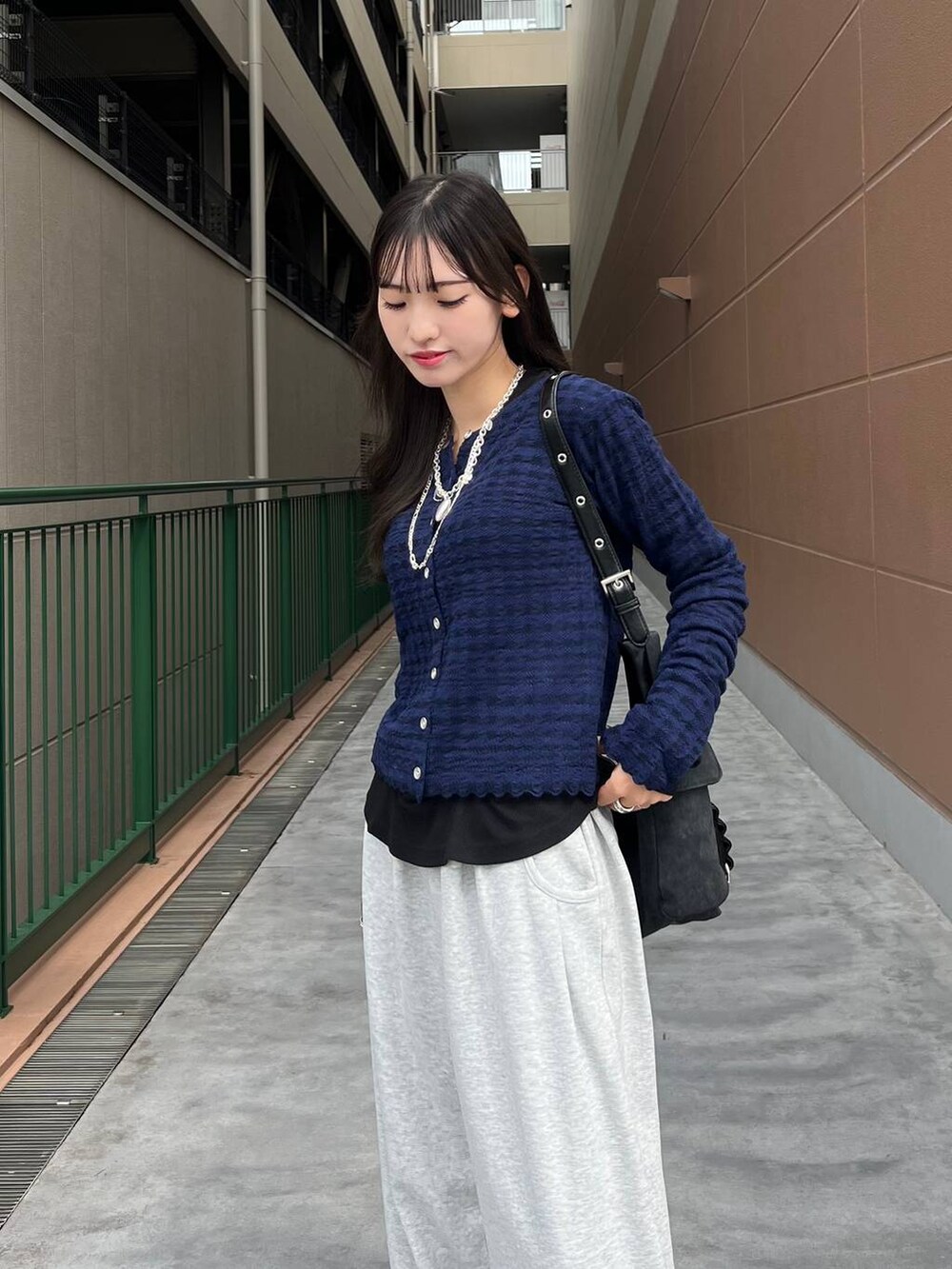 ブラック系のTシャツ/カットソー、ブラック系のショルダーバッグ、ブラック系のローファーを着用したレディースの秋コーディネートの2枚目の写真