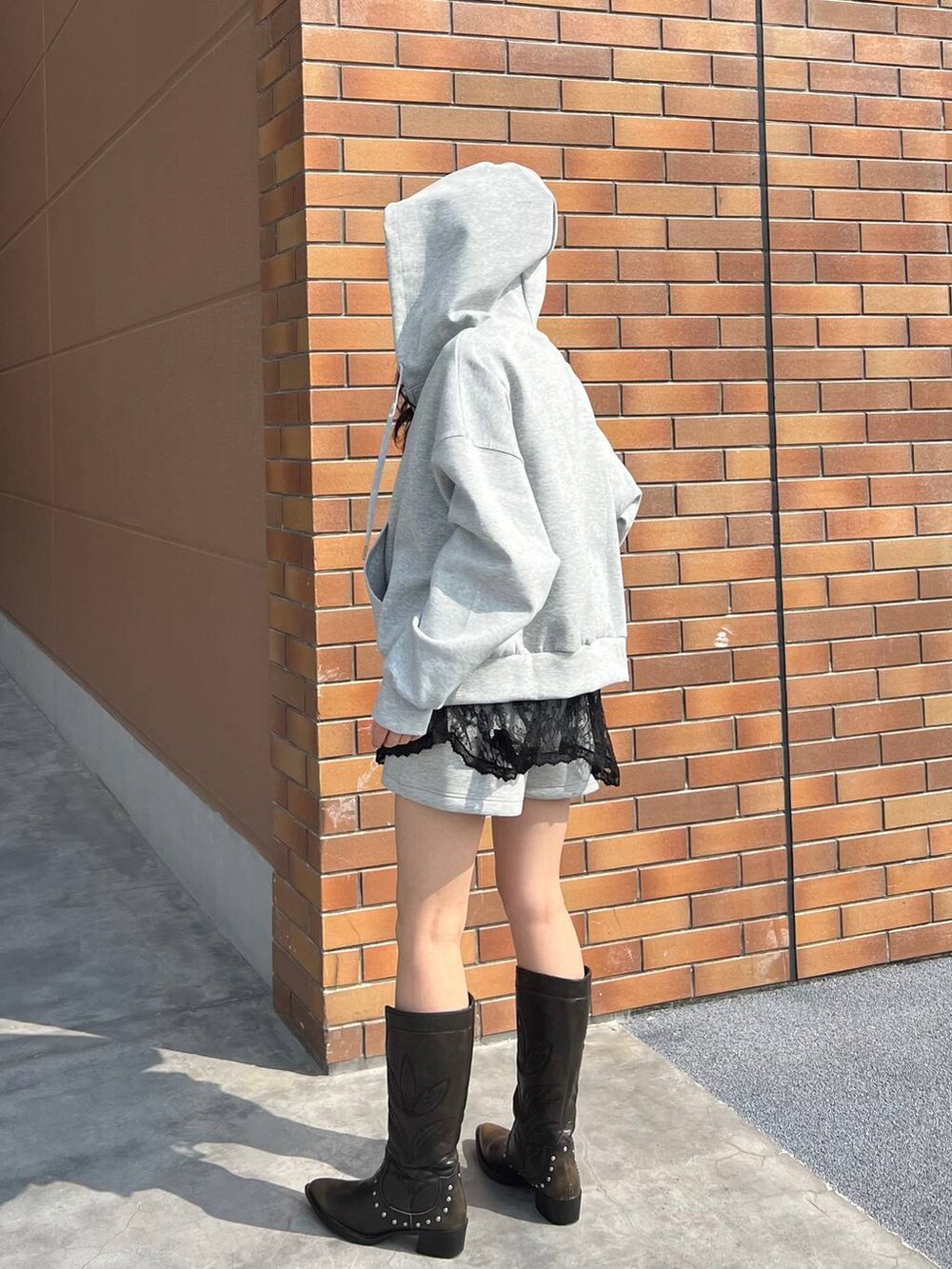 ブラック系のブーツ、グレー系のスウェットパンツ、グレー系のパーカーを着用したレディースの春コーディネートの5枚目の写真