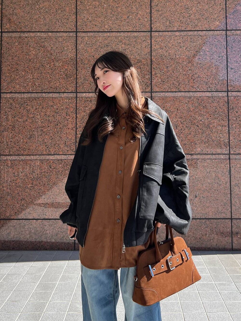 ブルー系のデニムパンツ、ブラック系のブルゾン、ブラウン系のその他シューズを着用したレディースの秋コーディネートの4枚目の写真