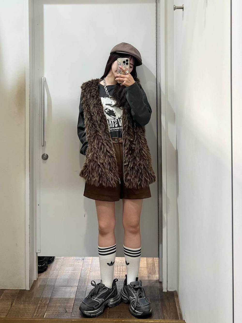 ブラウン系のベスト、グレー系のスニーカー、グレー系のTシャツ/カットソーを着用したレディースの秋コーディネートの5枚目の写真