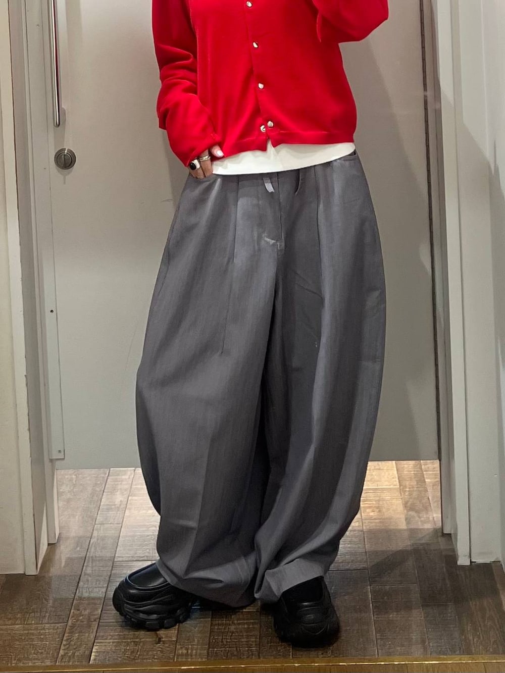 ブラック系のローファー、グレー系のスラックス、レッド系のカーディガン/ボレロを着用したレディースの春コーディネートの4枚目の写真