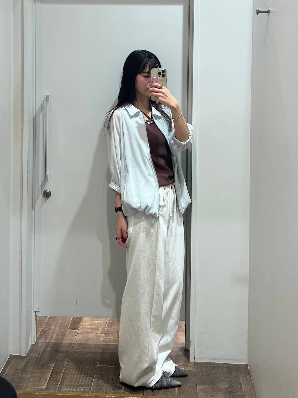ホワイト系のデニムパンツ、ブラウン系のタンクトップ、ブラック系のパンプスを着用したレディースの夏コーディネートの3枚目の写真