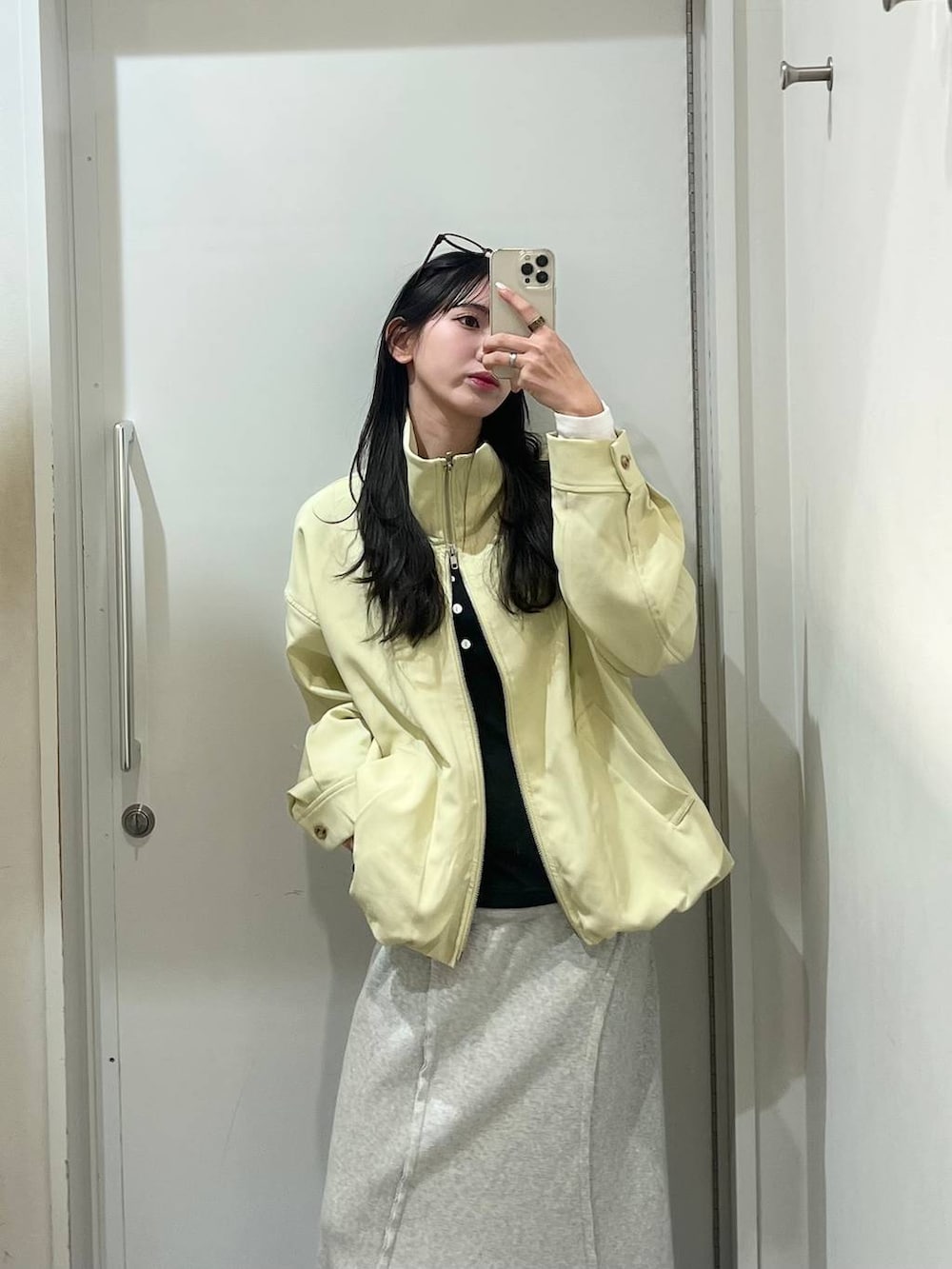 ブラック系のローファー、イエロー系のブルゾン、グレー系のスカートを着用したレディースの春コーディネートの6枚目の写真