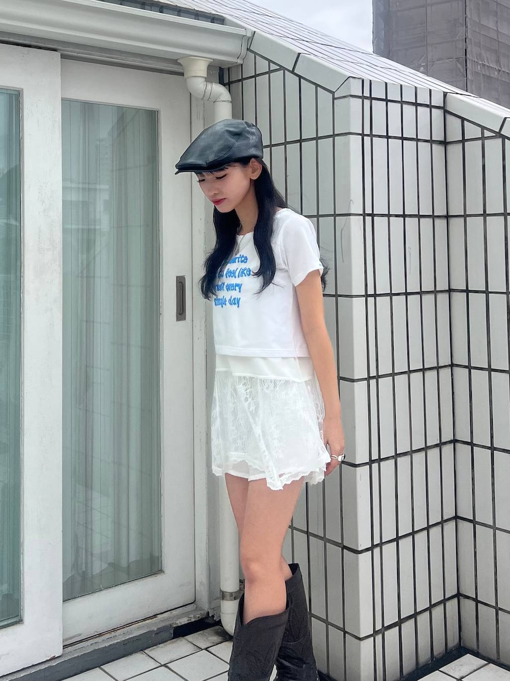 ブラック系のブーツ、ホワイト系のキャミソール、ブラック系のハンチング/ベレー帽を着用したレディースの春コーディネートの3枚目の写真