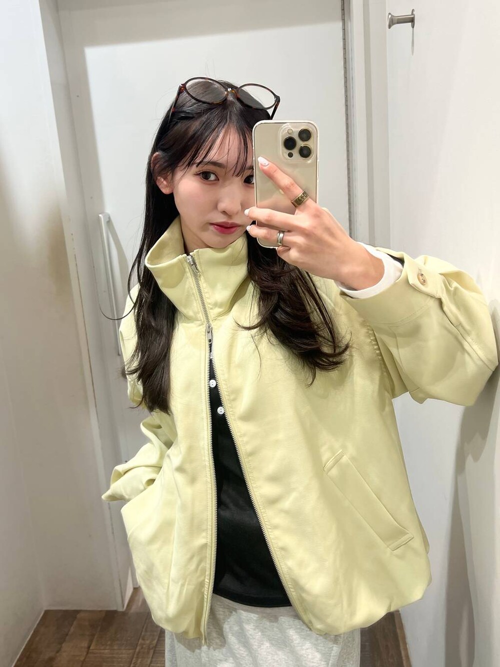 ブラック系のローファー、イエロー系のブルゾン、グレー系のスカートを着用したレディースの春コーディネートの2枚目の写真