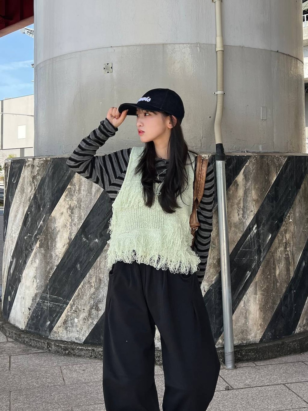 ブラック系のTシャツ/カットソー、ブラック系のスウェットパンツ、ブラウン系のボストンバッグを着用したレディースの冬コーディネートの5枚目の写真