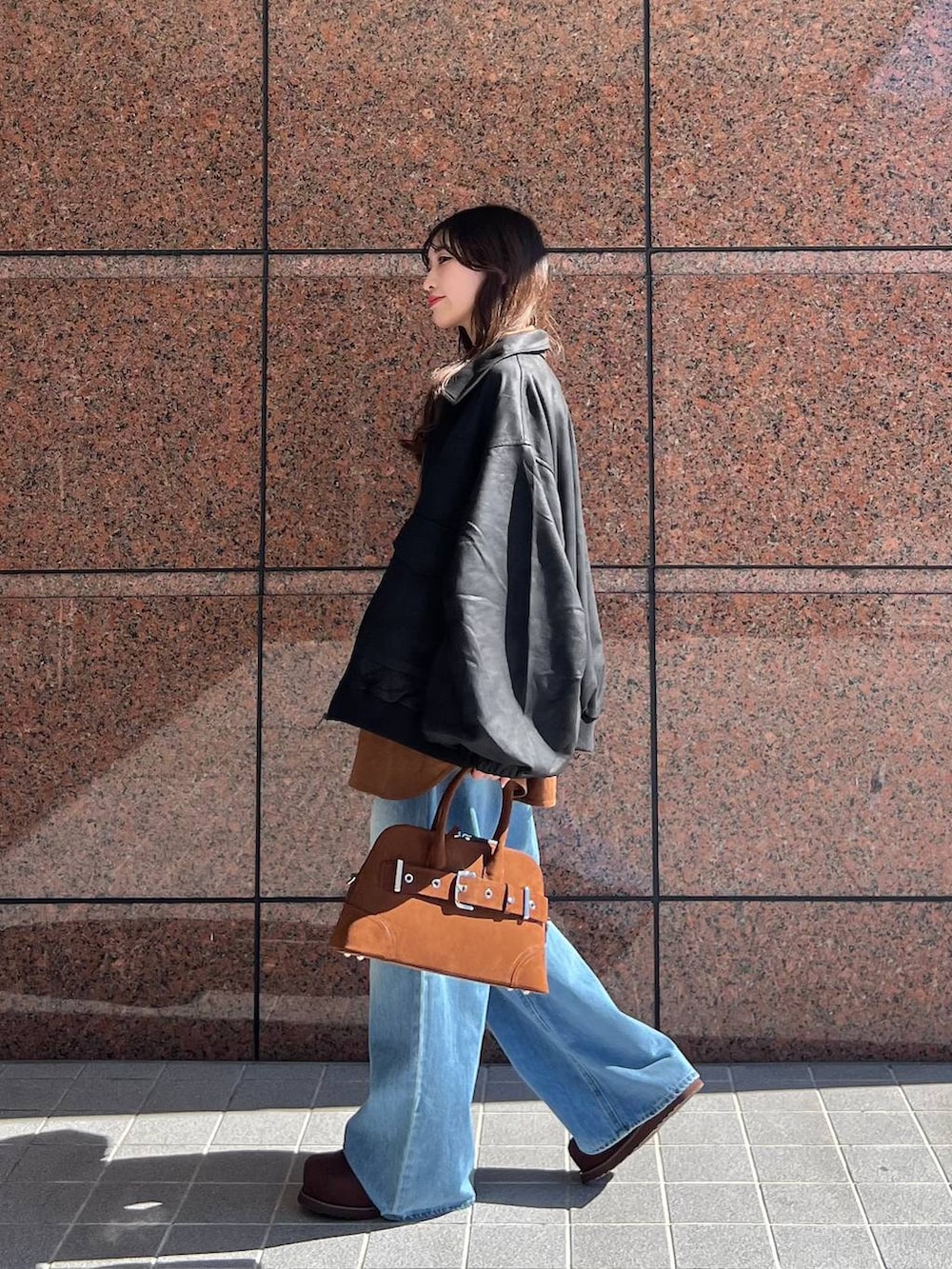 ブルー系のデニムパンツ、ブラック系のブルゾン、ブラウン系のその他シューズを着用したレディースの秋コーディネートの2枚目の写真