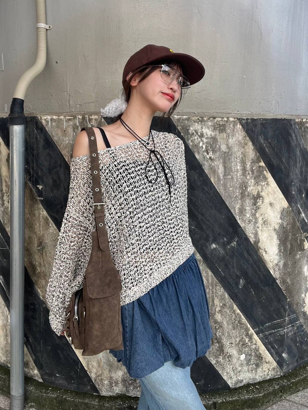 ブラウン系のショルダーバッグ、ブラウン系のスニーカー、ブルー系のデニムスカートを着用したレディースの夏コーディネートの3枚目の写真