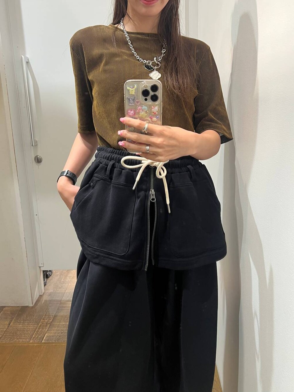 ブラック系のスニーカー、ブラック系のスウェットパンツ、ブラック系のスカートを着用したレディースの夏コーディネートの4枚目の写真