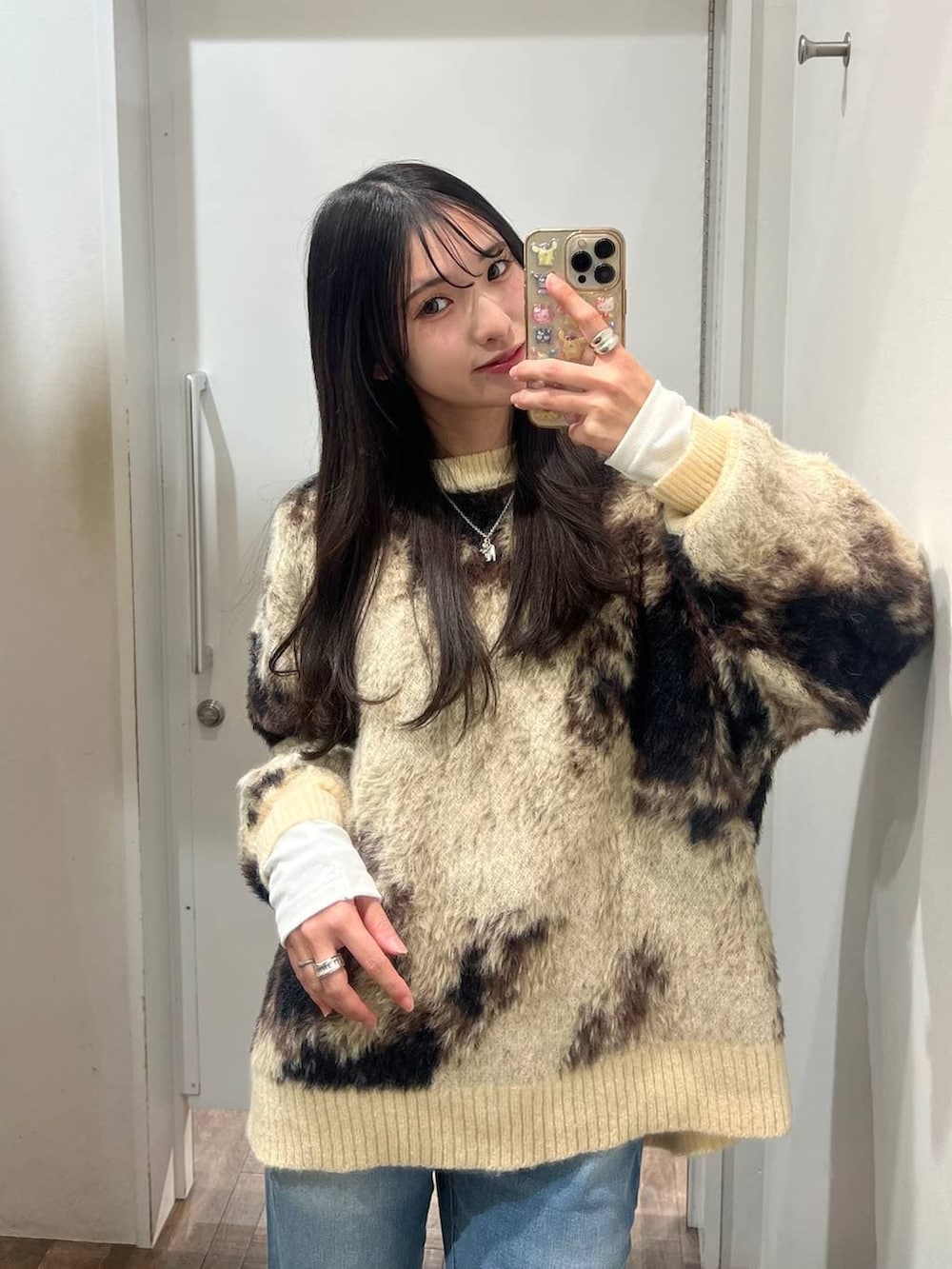 ホワイト系のTシャツ/カットソー、ブラウン系のニット/セーター、ブラック系のスニーカーを着用したレディースの冬コーディネートの3枚目の写真