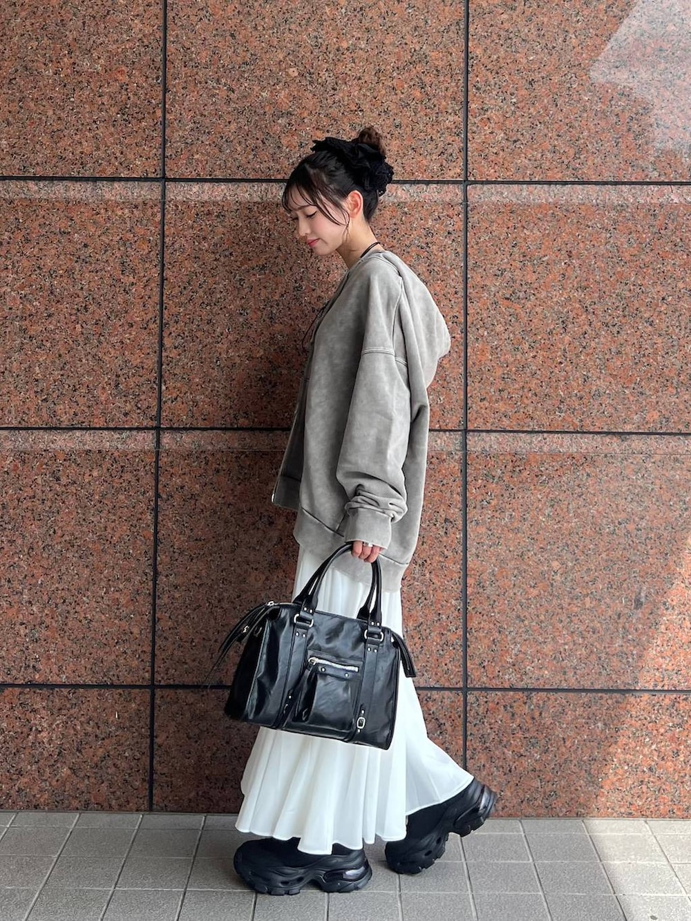 グレー系のパーカー、ブラック系のボストンバッグ、ブラック系のブーツを着用したレディースの夏コーディネートの7枚目の写真