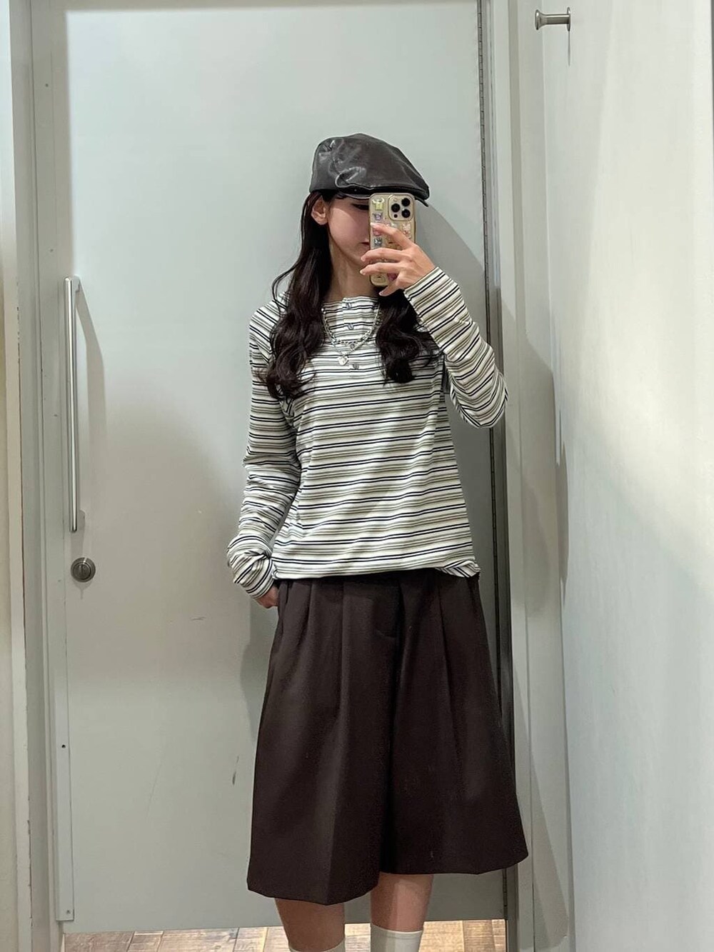 ホワイト系のTシャツ/カットソー、ブラウン系のテーラードジャケット、ブラック系のパンプスを着用したレディースの冬コーディネートの2枚目の写真