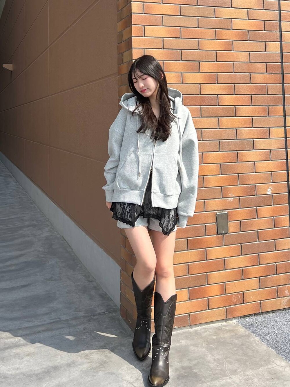 ブラック系のブーツ、グレー系のスウェットパンツ、グレー系のパーカーを着用したレディースの春コーディネートの8枚目の写真