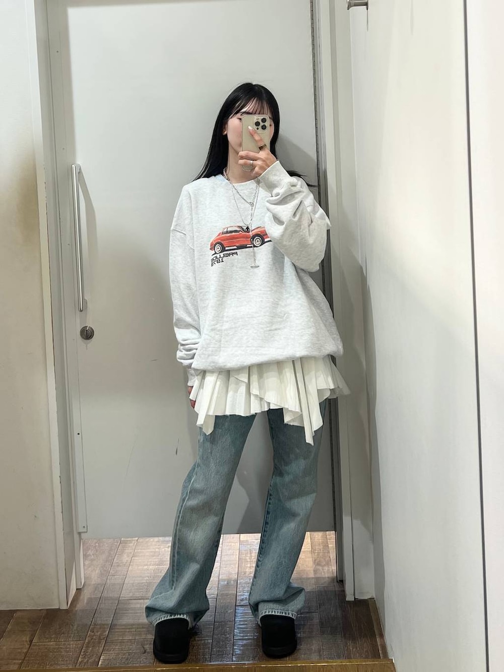 グレー系のスウェット、ブルー系のデニムパンツ、ブラック系のモカシン/デッキシューズを着用したレディースの春コーディネートの4枚目の写真