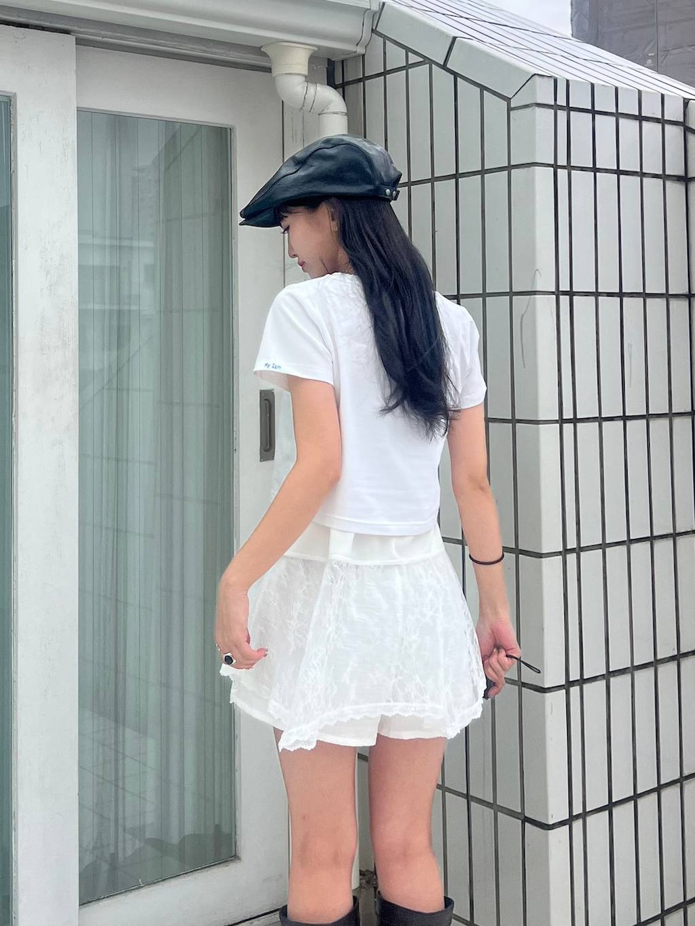 ブラック系のブーツ、ホワイト系のキャミソール、ブラック系のハンチング/ベレー帽を着用したレディースの春コーディネートの4枚目の写真