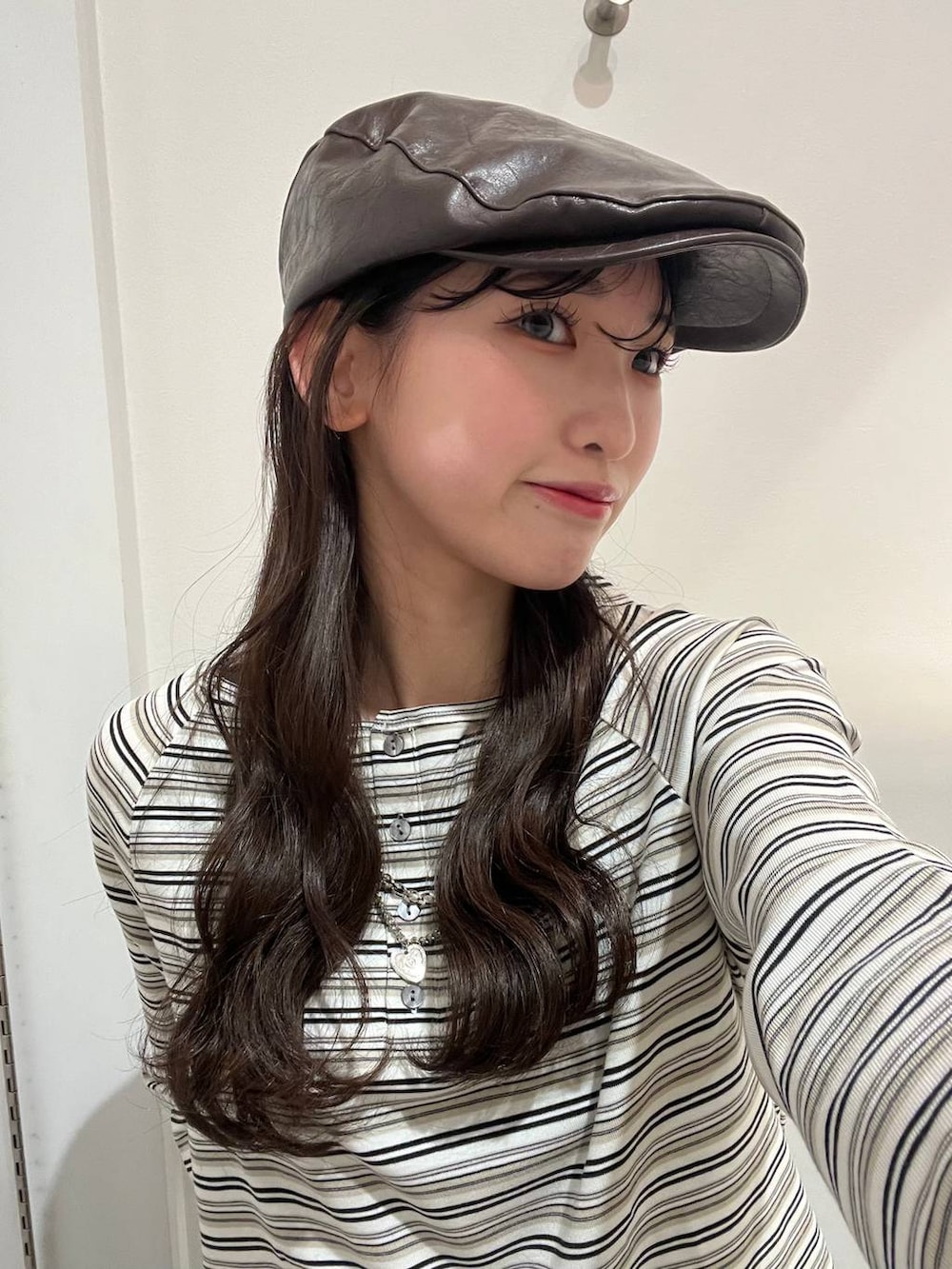 ホワイト系のTシャツ/カットソー、ブラウン系のテーラードジャケット、ブラック系のパンプスを着用したレディースの冬コーディネートの6枚目の写真