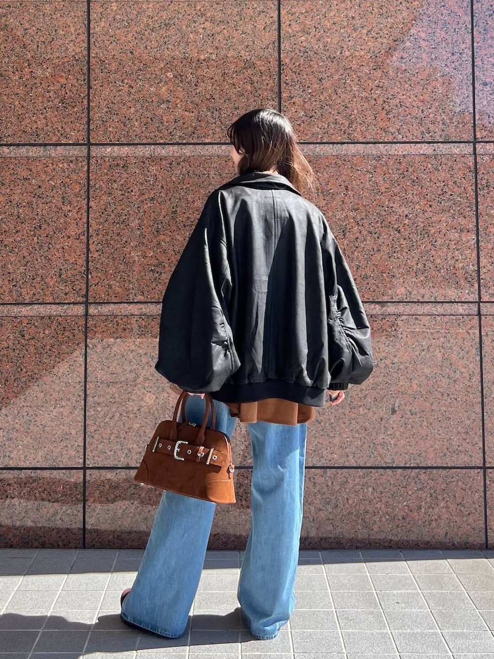 ブルー系のデニムパンツ、ブラック系のブルゾン、ブラウン系のその他シューズを着用したレディースの秋コーディネートの3枚目の写真