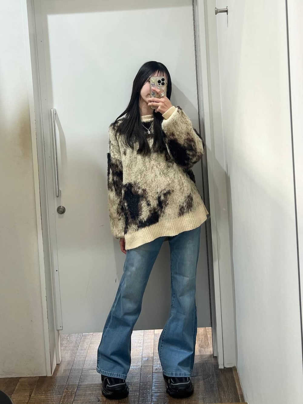 ホワイト系のTシャツ/カットソー、ブラウン系のニット/セーター、ブラック系のスニーカーを着用したレディースの冬コーディネートの4枚目の写真