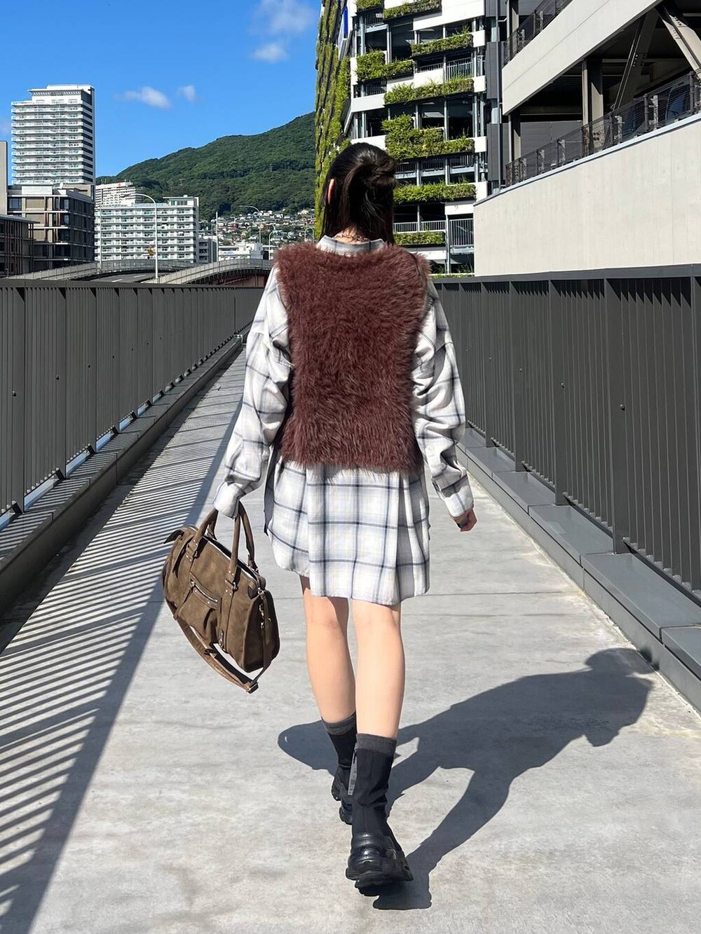 ブラウン系のベスト、ホワイト系のシャツ/ブラウス、ブラウン系のボストンバッグを着用したレディースの秋コーディネートの6枚目の写真