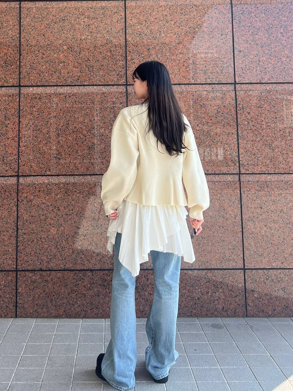 ブルー系のデニムパンツ、ブラック系のモカシン/デッキシューズ、ホワイト系のカーディガン/ボレロを着用したレディースの春コーディネートの3枚目の写真