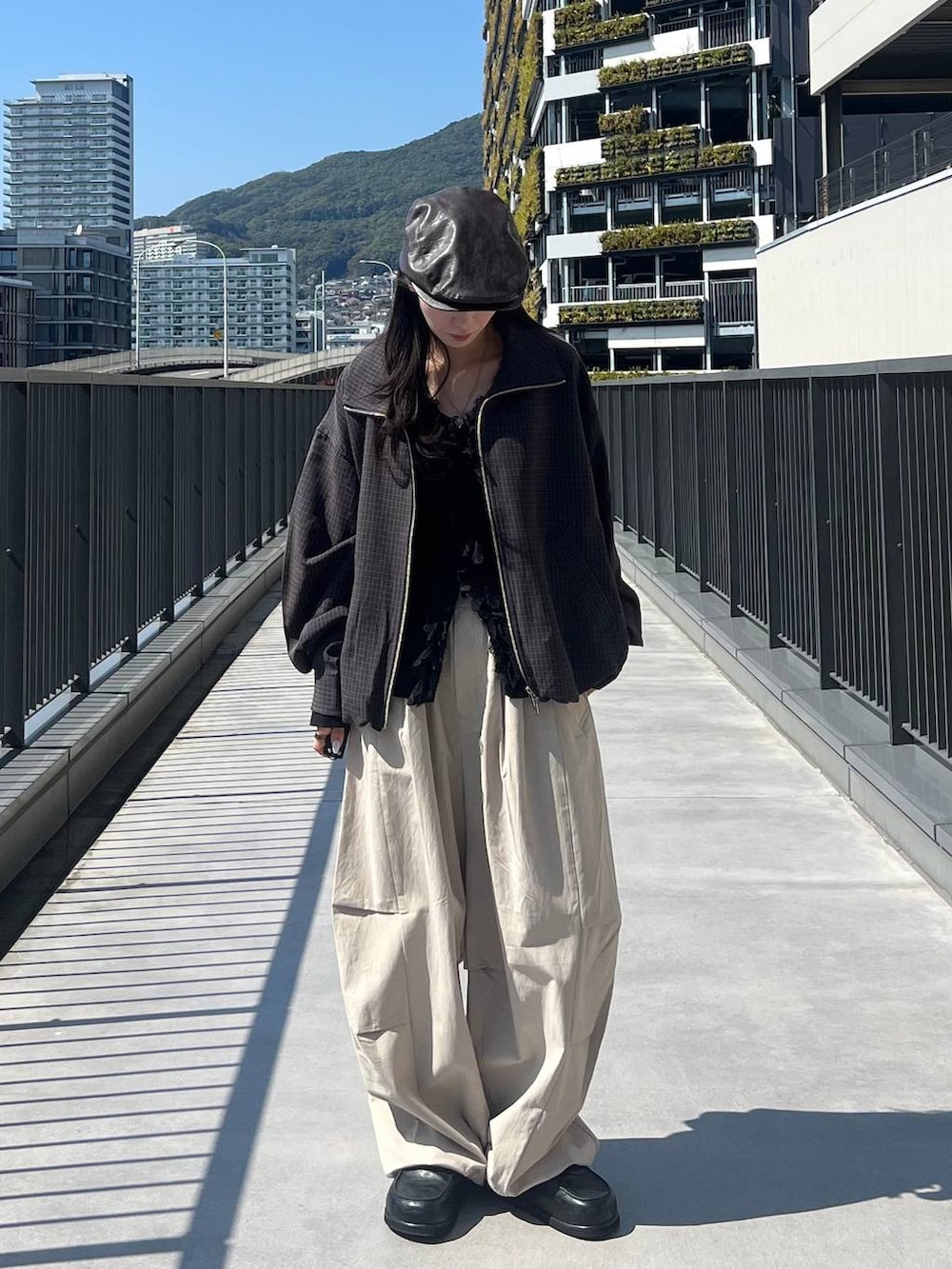 ブラック系のローファー、ブルー系のブルゾン、ブラック系のカーディガン/ボレロを着用したレディースの春コーディネートの5枚目の写真