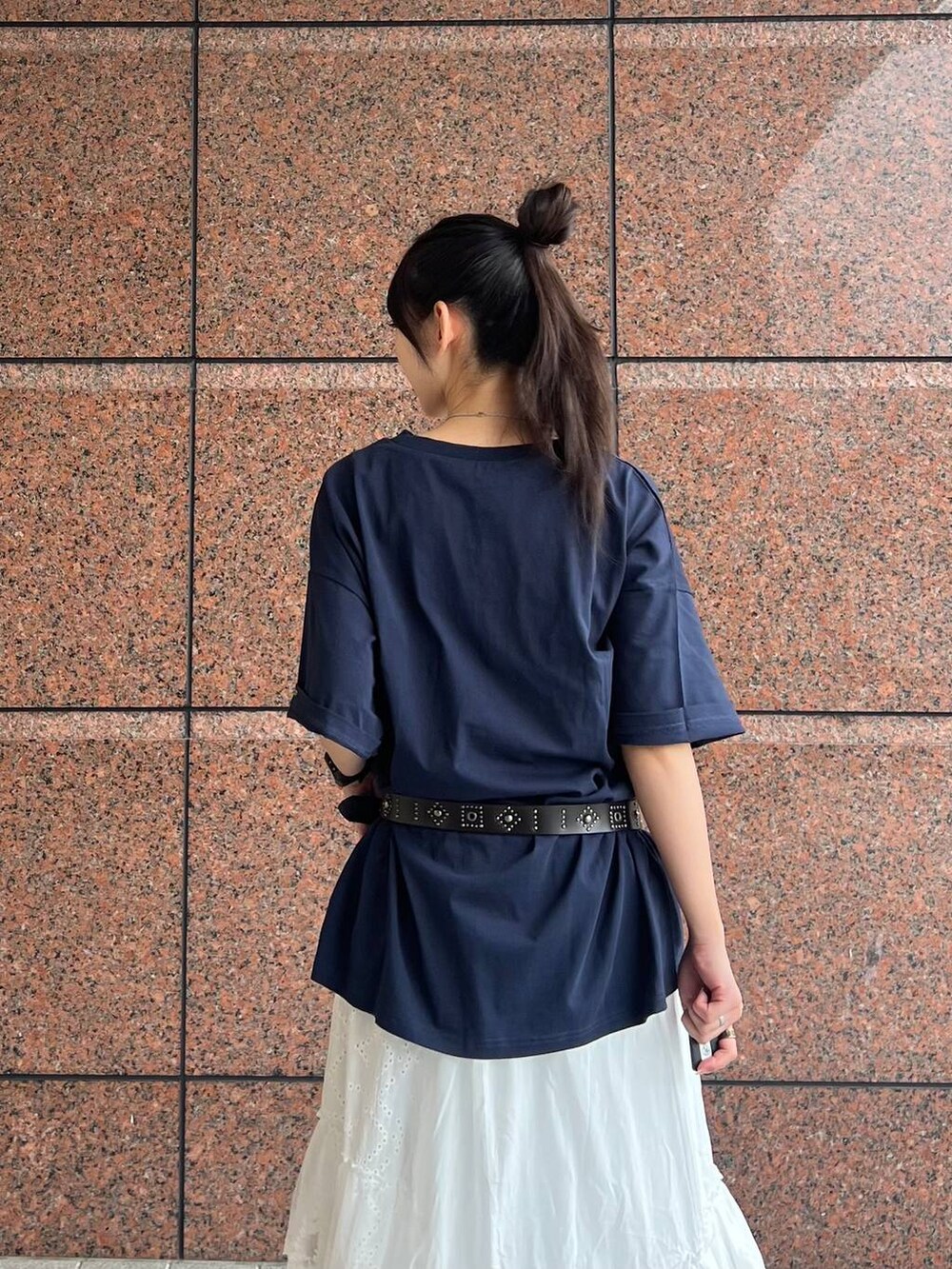 ベージュ系のローファー、ホワイト系のスカート、ブルー系のデニムパンツを着用したレディースの春コーディネートの3枚目の写真