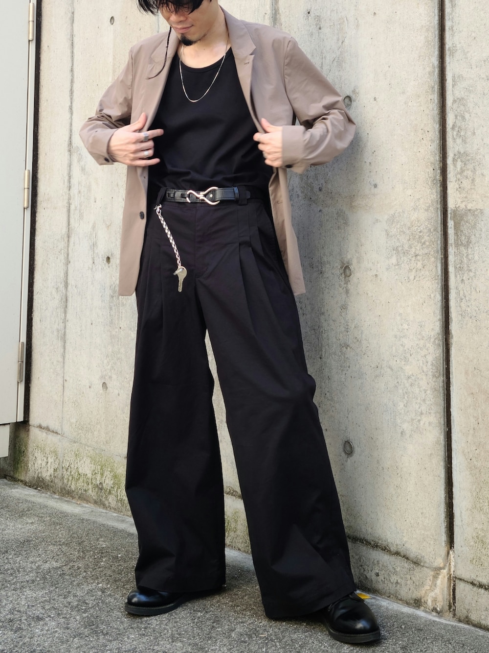 ベージュ系のテーラードジャケット、ベージュ系のその他パンツ、ブラック系のタンクトップを着用したメンズの春コーディネートの3枚目の写真