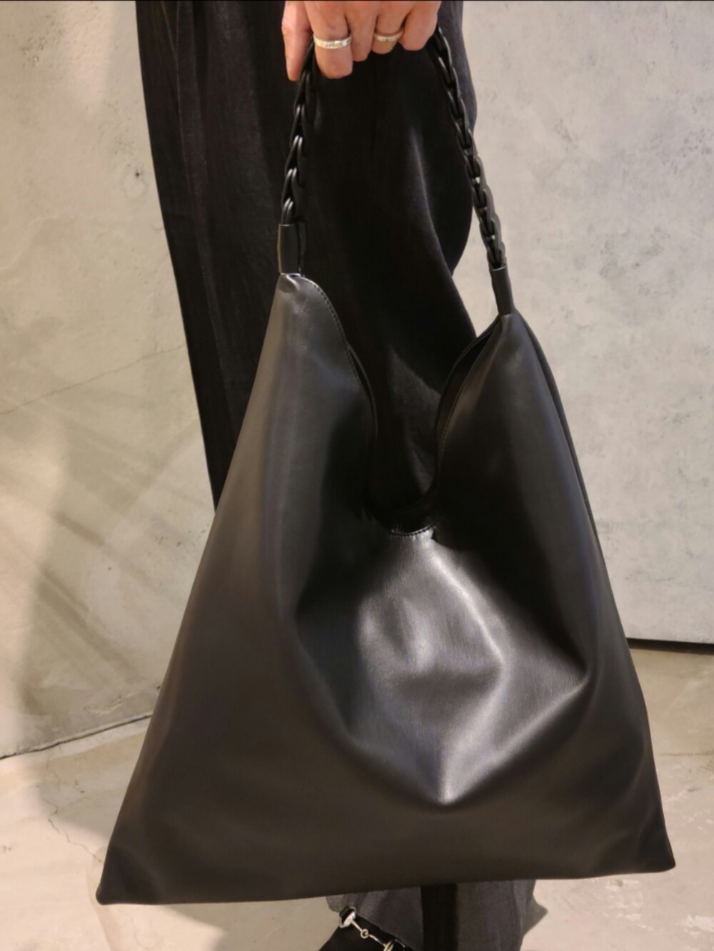 ブラック系のポロシャツ、ブラック系のデニムパンツ、ブラック系のサンダルを着用したメンズの夏コーディネートの3枚目の写真