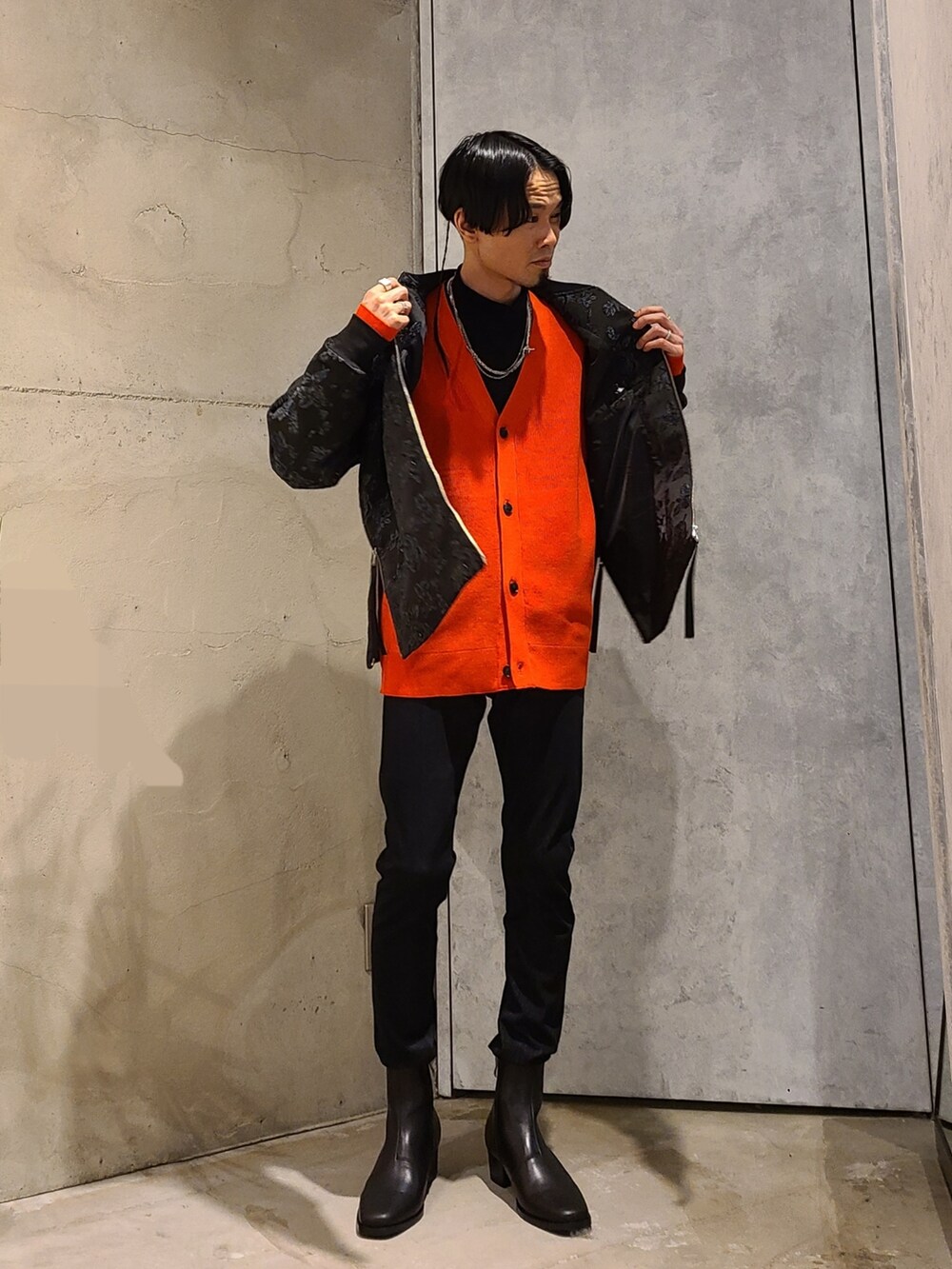 ブラック系のブルゾン、レッド系のカーディガン/ボレロ、ブラック系のTシャツ/カットソーを着用したメンズの冬コーディネートの2枚目の写真