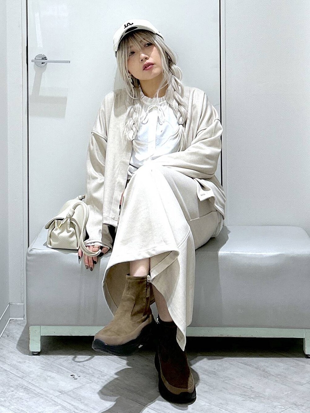 ベージュ系のショルダーバッグ、ブラウン系のブーツ、ホワイト系のシャツ/ブラウスを着用したレディースの秋コーディネートの6枚目の写真