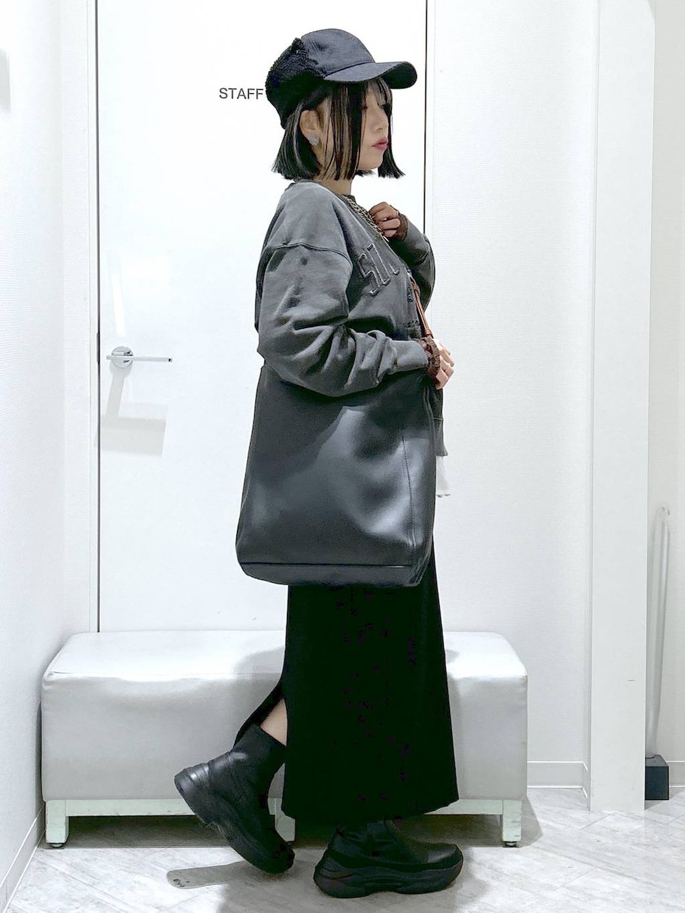 ブラック系のショルダーバッグ、ブラック系のブーツ、ブラック系のスカートを着用したレディースの秋コーディネートの6枚目の写真