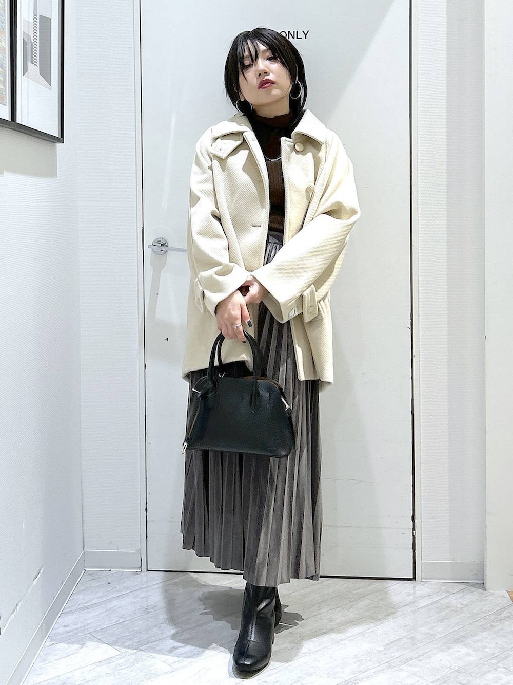 ブラック系のショルダーバッグ、グレー系のスカート、ブラック系のブーツを着用したレディースの秋コーディネートの9枚目の写真