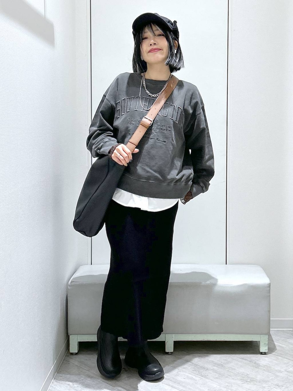 ブラック系のショルダーバッグ、ブラック系のブーツ、ブラック系のスカートを着用したレディースの秋コーディネートの9枚目の写真
