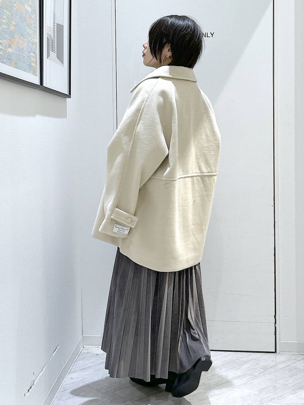 ブラック系のショルダーバッグ、グレー系のスカート、ブラック系のブーツを着用したレディースの秋コーディネートの4枚目の写真