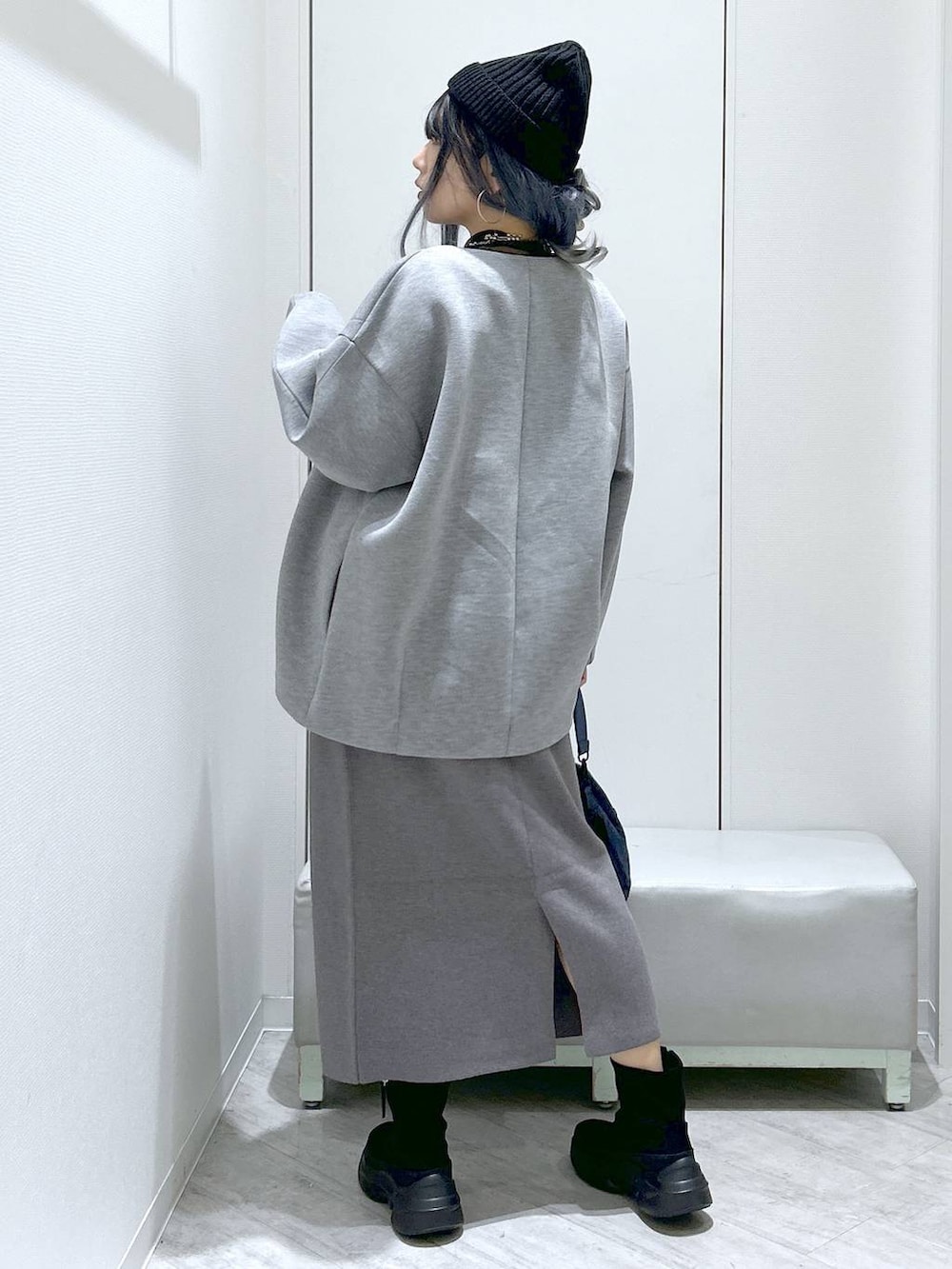 グレー系のスカート、グレー系のブルゾン、ブラック系のブーツを着用したレディースの秋コーディネートの5枚目の写真