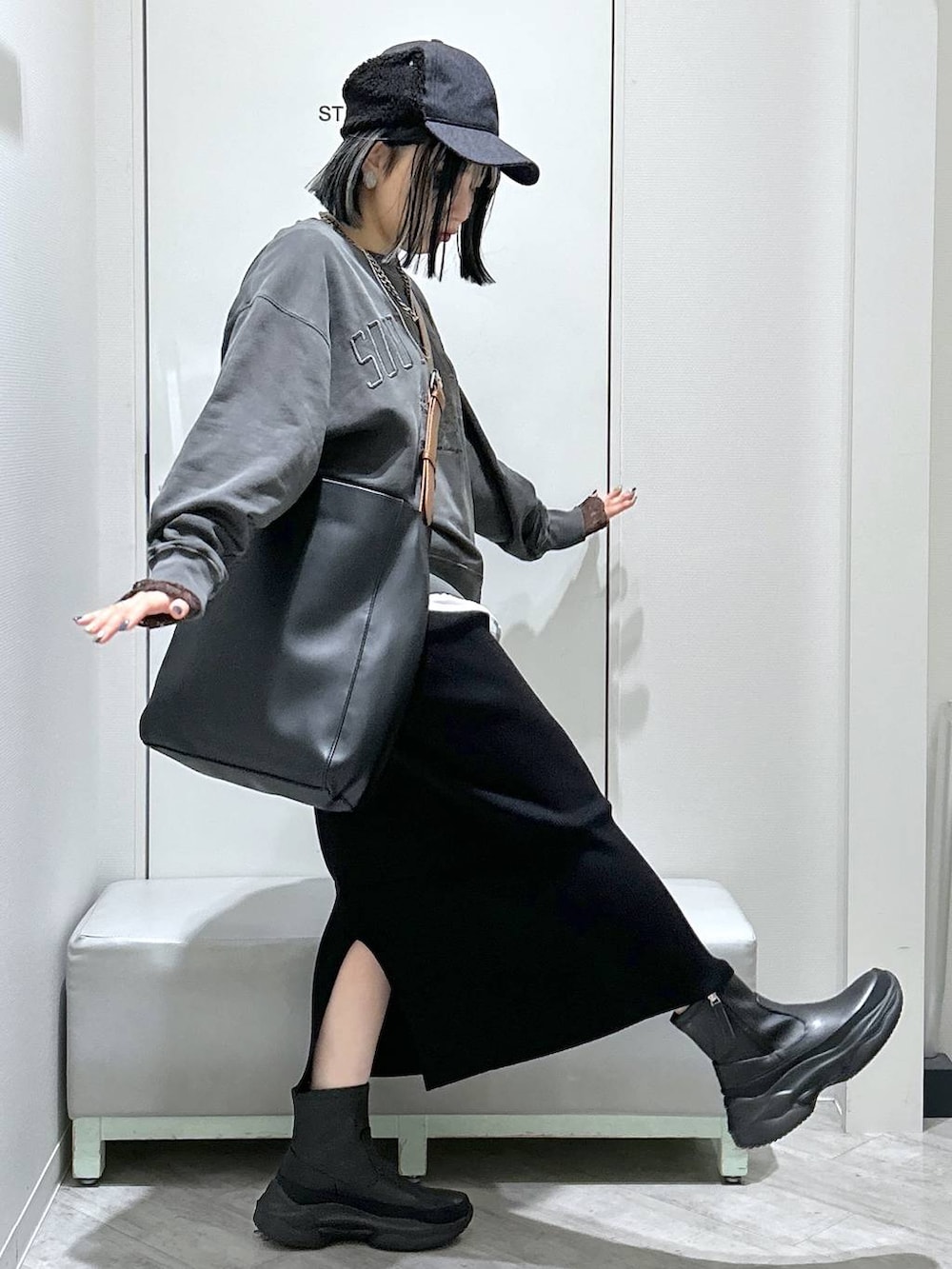 ブラック系のショルダーバッグ、ブラック系のブーツ、ブラック系のスカートを着用したレディースの秋コーディネートの8枚目の写真