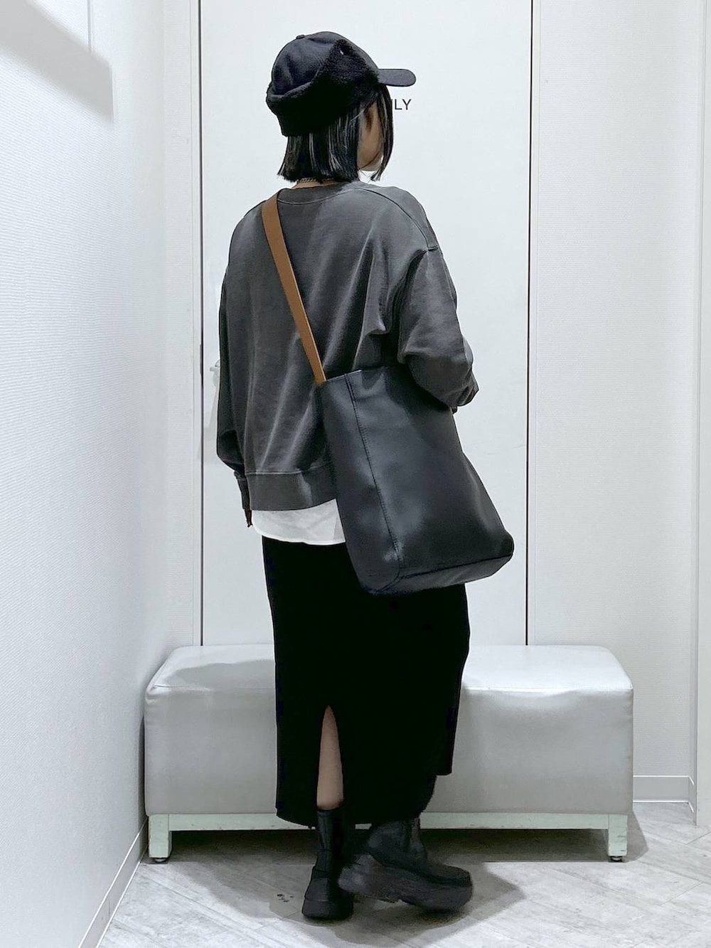 ブラック系のショルダーバッグ、ブラック系のブーツ、ブラック系のスカートを着用したレディースの秋コーディネートの5枚目の写真