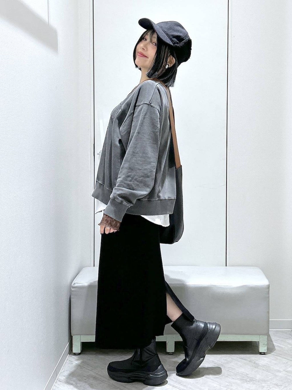 ブラック系のショルダーバッグ、ブラック系のブーツ、ブラック系のスカートを着用したレディースの秋コーディネートの3枚目の写真