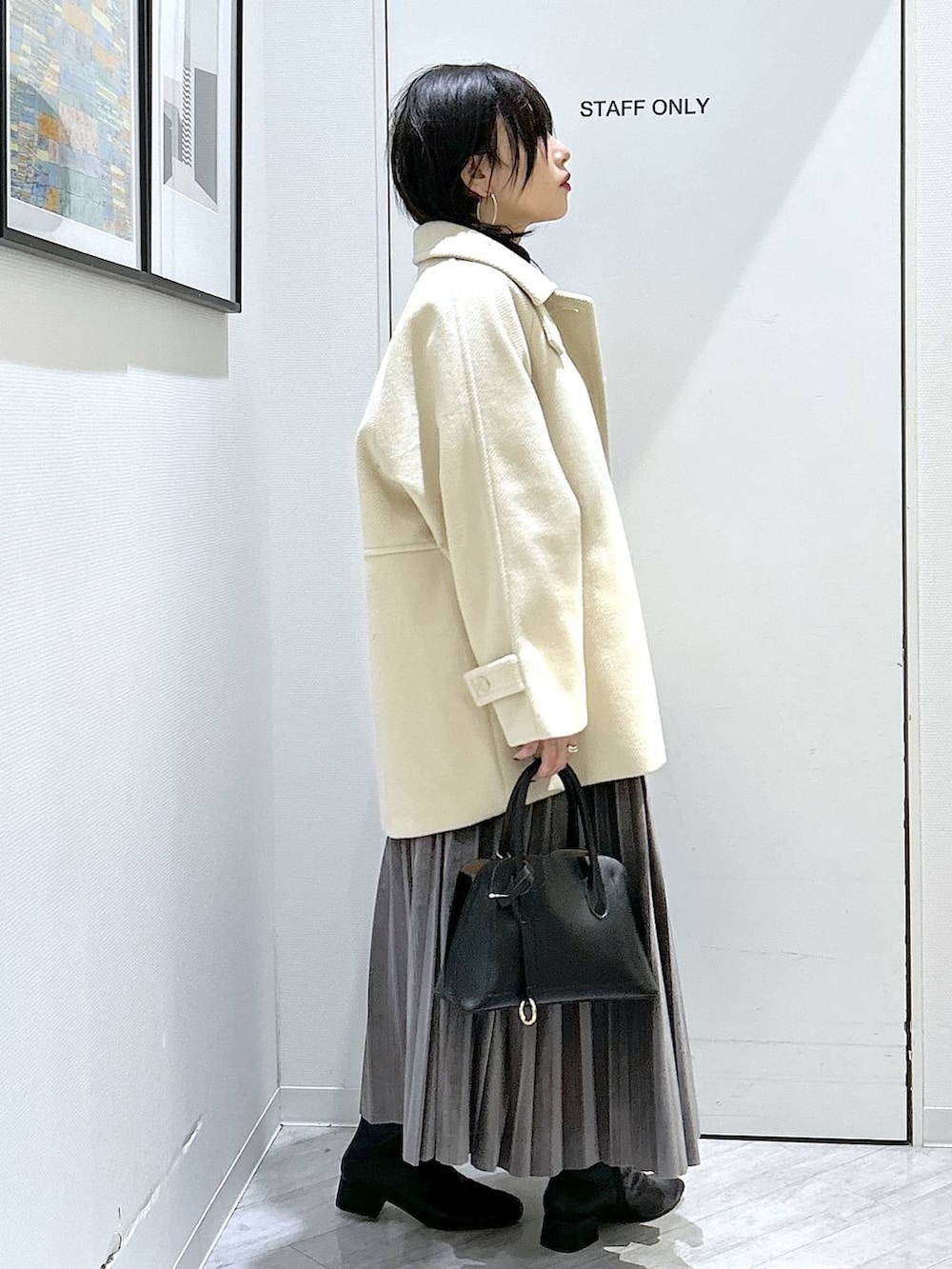 ブラック系のショルダーバッグ、グレー系のスカート、ブラック系のブーツを着用したレディースの秋コーディネートの6枚目の写真