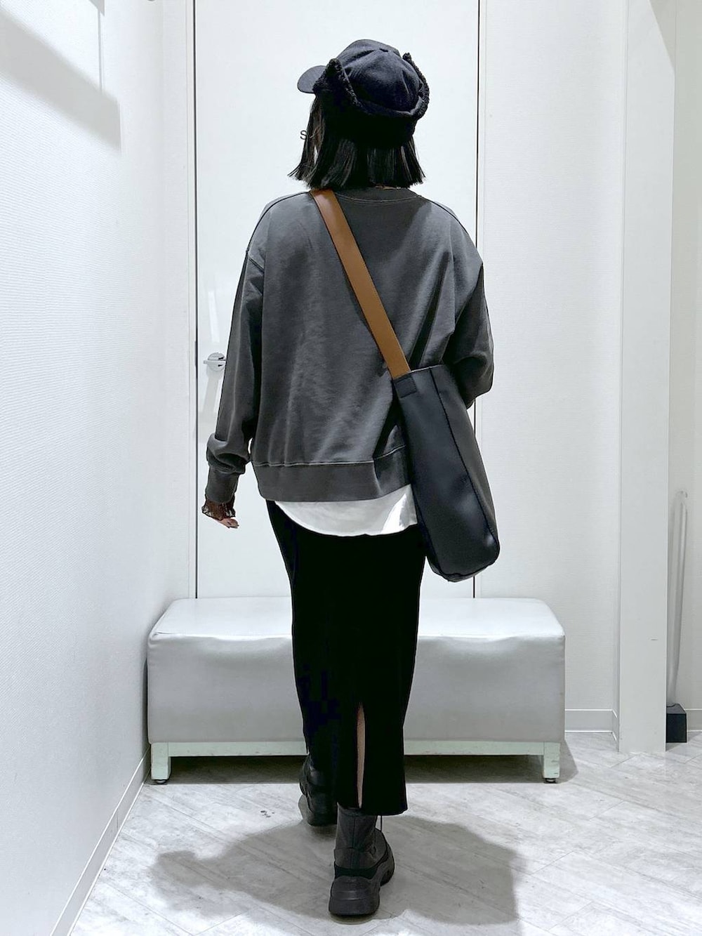 ブラック系のショルダーバッグ、ブラック系のブーツ、ブラック系のスカートを着用したレディースの秋コーディネートの4枚目の写真