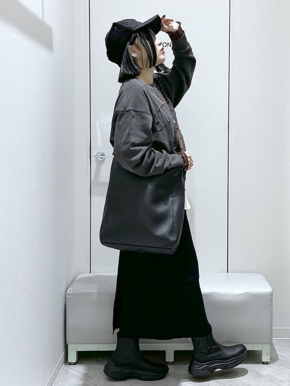 ブラック系のショルダーバッグ、ブラック系のブーツ、ブラック系のスカートを着用したレディースの秋コーディネートの7枚目の写真